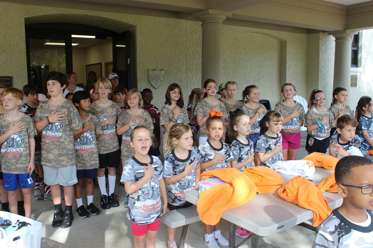 Students at The Bolles Lower School Ponte Vedra Beach Campus pledge allegiance to the flag during a recent military appreciation-themed field day.